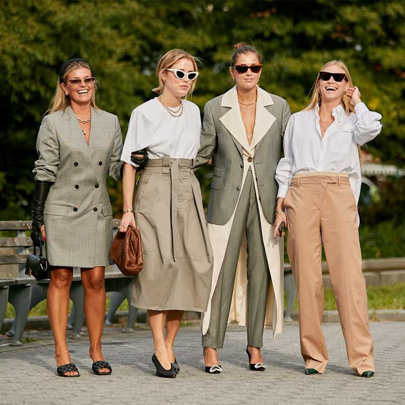 Vier Frauen tragen Outfits in den Farben Salbeigrün und Beige